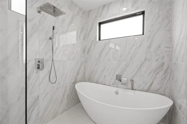 a bathroom with a white bath tub sitting next to a window