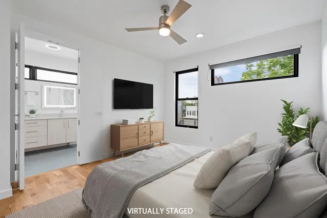 a bedroom with a bed window and a flat screen tv