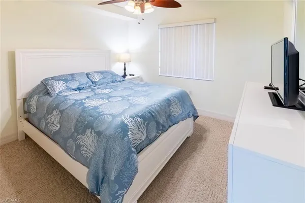 a bedroom with a bed and a flat tv screen on the dresser