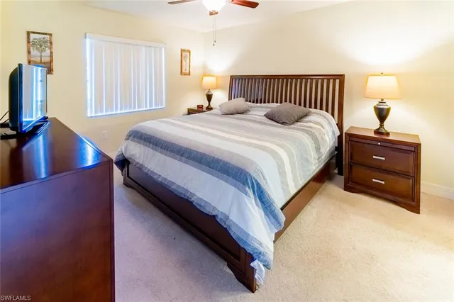 a bedroom with a bed and a flat tv screen on dresser