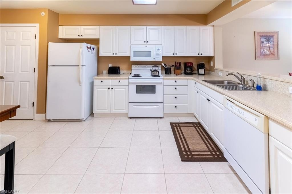 1100 Eastham Way, Unit A105 Naples, FL 34104 - Photo 6 of 27 a kitchen with cabinets and appliances