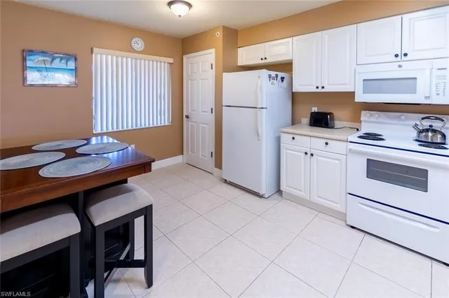a kitchen with stainless steel appliances a table chairs and a refrigerator