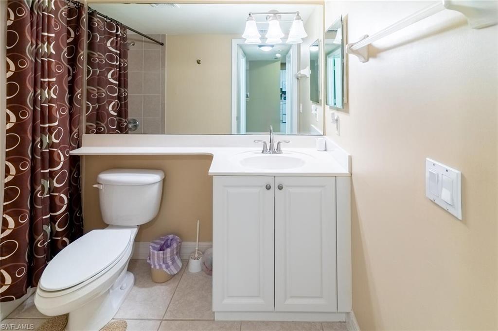 1100 Eastham Way, Unit A105 Naples, FL 34104 - Photo 9 of 27 a bathroom with a toilet sink and mirror