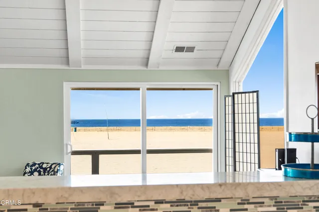 a kitchen with granite countertop a stove a sink and white cabinets with wooden floor