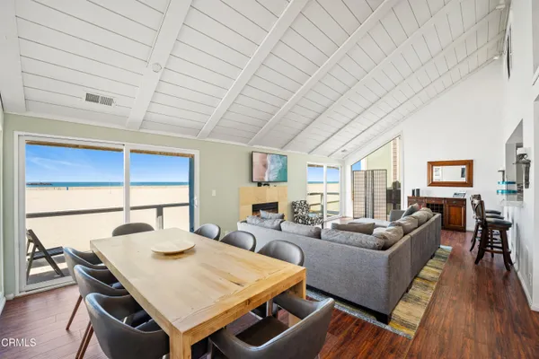 a living room with furniture a dining table and a wooden floor