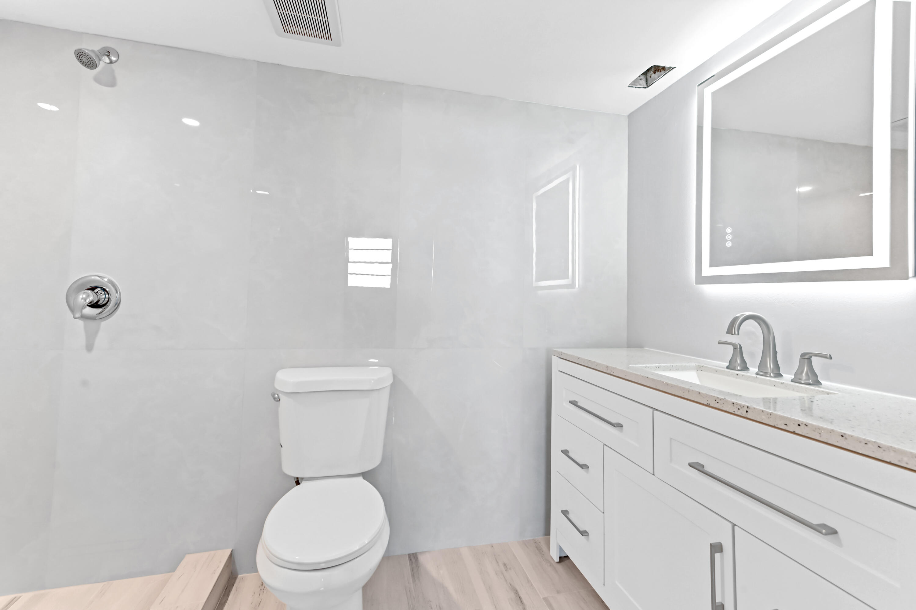 5500 Northwest 2nd Avenue, Unit 617 Boca Raton, FL 33487 - Photo 24 of 39 a bathroom with a toilet a sink a mirror and vanity