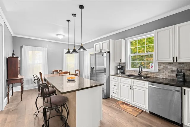 a kitchen with a sink stove and chairs