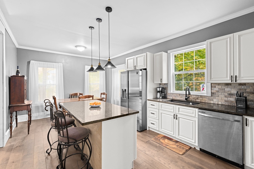 168 Spring Street Hanson, MA 02341 - Photo 15 of 40 a kitchen with a sink stove and chairs