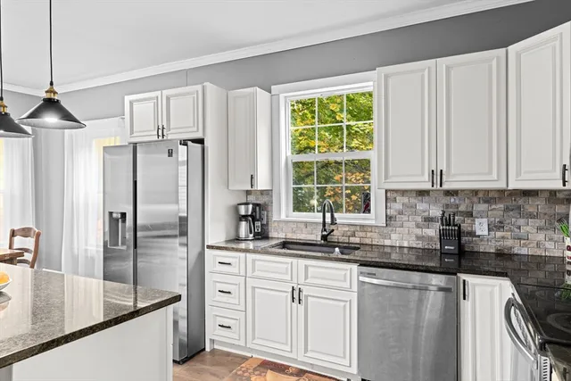 a kitchen with stainless steel appliances granite countertop a sink a stove and a refrigerator