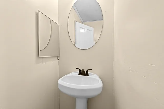 a bathroom with a sink a mirror and a lamp