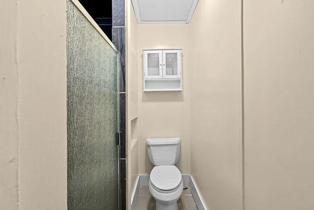 a white toilet sitting next to a shower