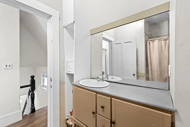 a bathroom with a granite countertop sink and a mirror