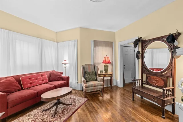 a living room with furniture a rug and a mirror