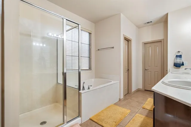 a bathroom with a tub sink shower and mirror