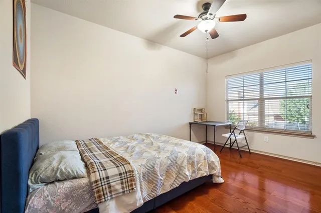 a bedroom with a bed table two chairs and a window