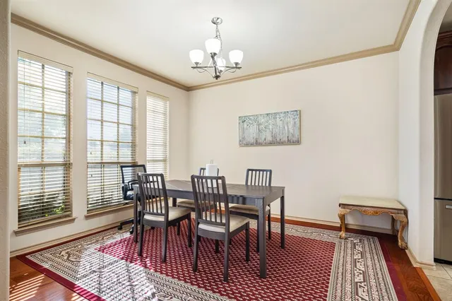 a view of a dining room with furniture a rug and wooden floor