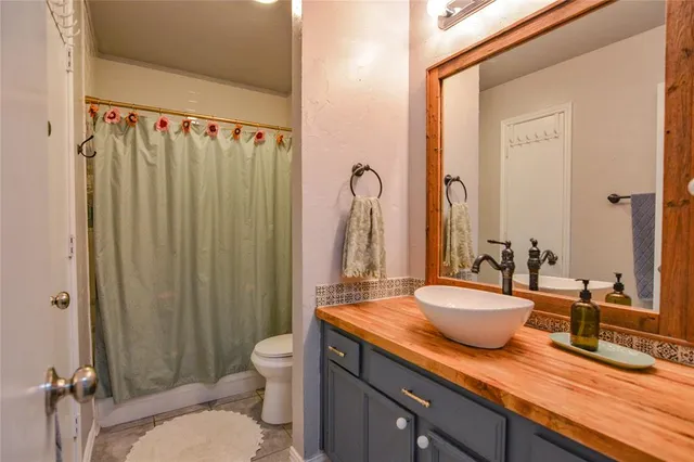 a bathroom with a granite countertop sink toilet and shower