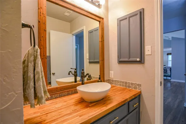 a bathroom with a granite countertop sink and a mirror