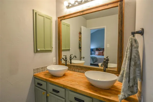 a bathroom with a granite countertop sink and a mirror