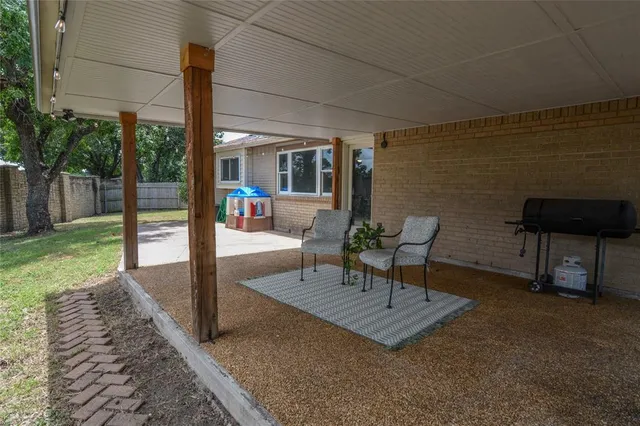 a view of a patio with a table chairs and a yard