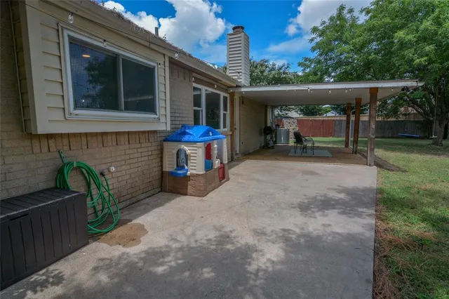 a view of a chair and table in backyard of the house