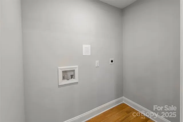 a room with wooden floor and white cabinets