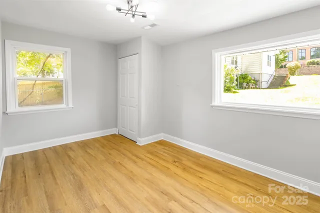 a view of empty room with wooden floor