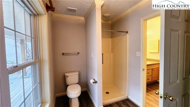 a bathroom with a toilet and a shower