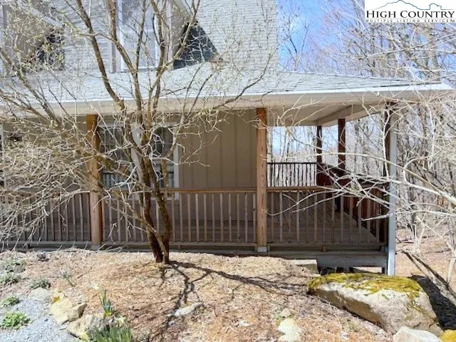 a view of a backyard with wooden fence and large trees