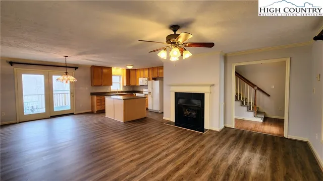 a view of a kitchen with a stove cabinets a ceiling fan and wooden floor
