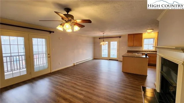 a view of an empty room with window and wooden floor