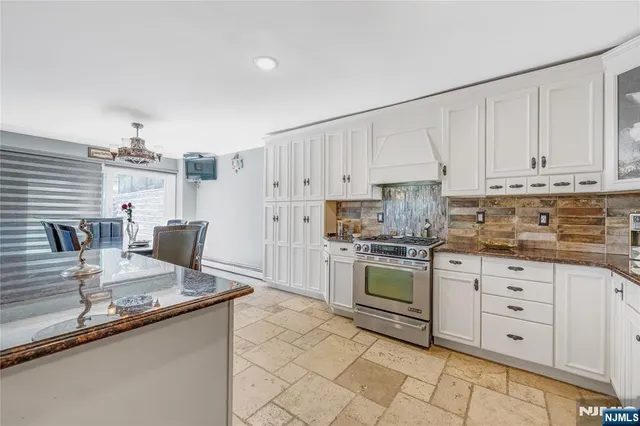 a kitchen with granite countertop a stove sink and cabinets