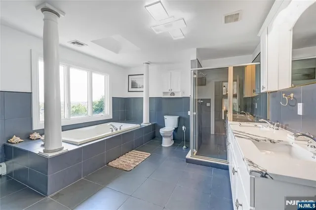 a bathroom with a tub sink and mirror