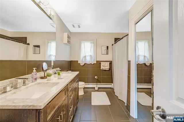 a spacious bathroom with a granite countertop sink a mirror and shower