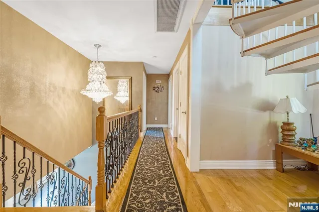 a view of a hallway with wooden floor and staircase