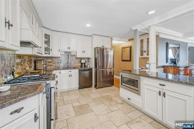 a kitchen with granite countertop a refrigerator stove top oven and sink