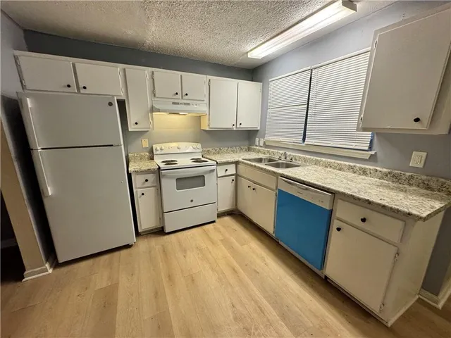 a kitchen with a sink a refrigerator and cabinets