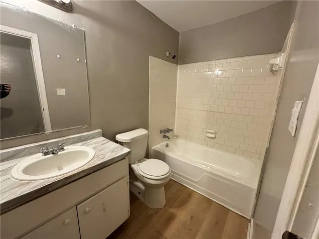 a bathroom with a sink a toilet a mirror a bathtub and shower