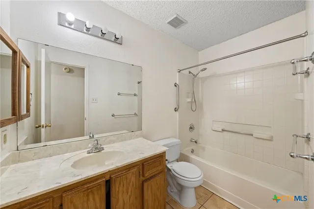 a bathroom with a granite countertop sink toilet mirror and bathtub