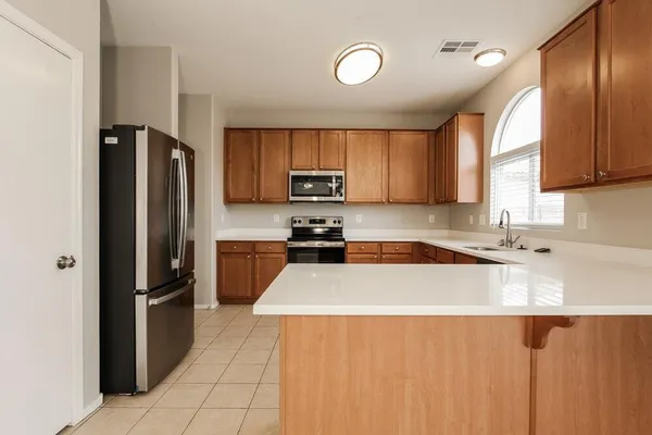 a kitchen with granite countertop a refrigerator and a sink