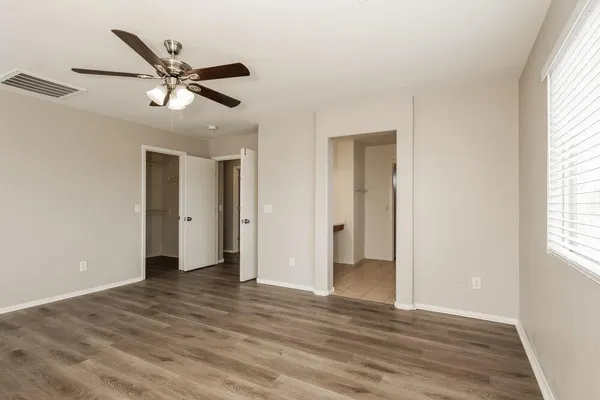a view of an empty room and window and wooden floor