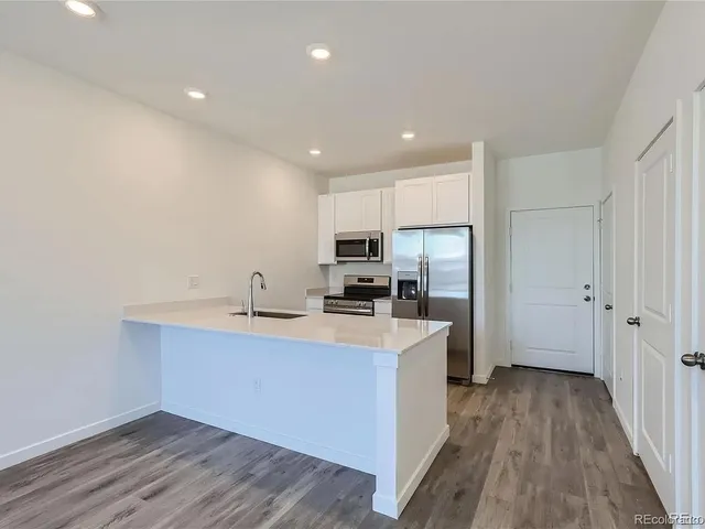 a kitchen with cabinets a sink and wooden floor
