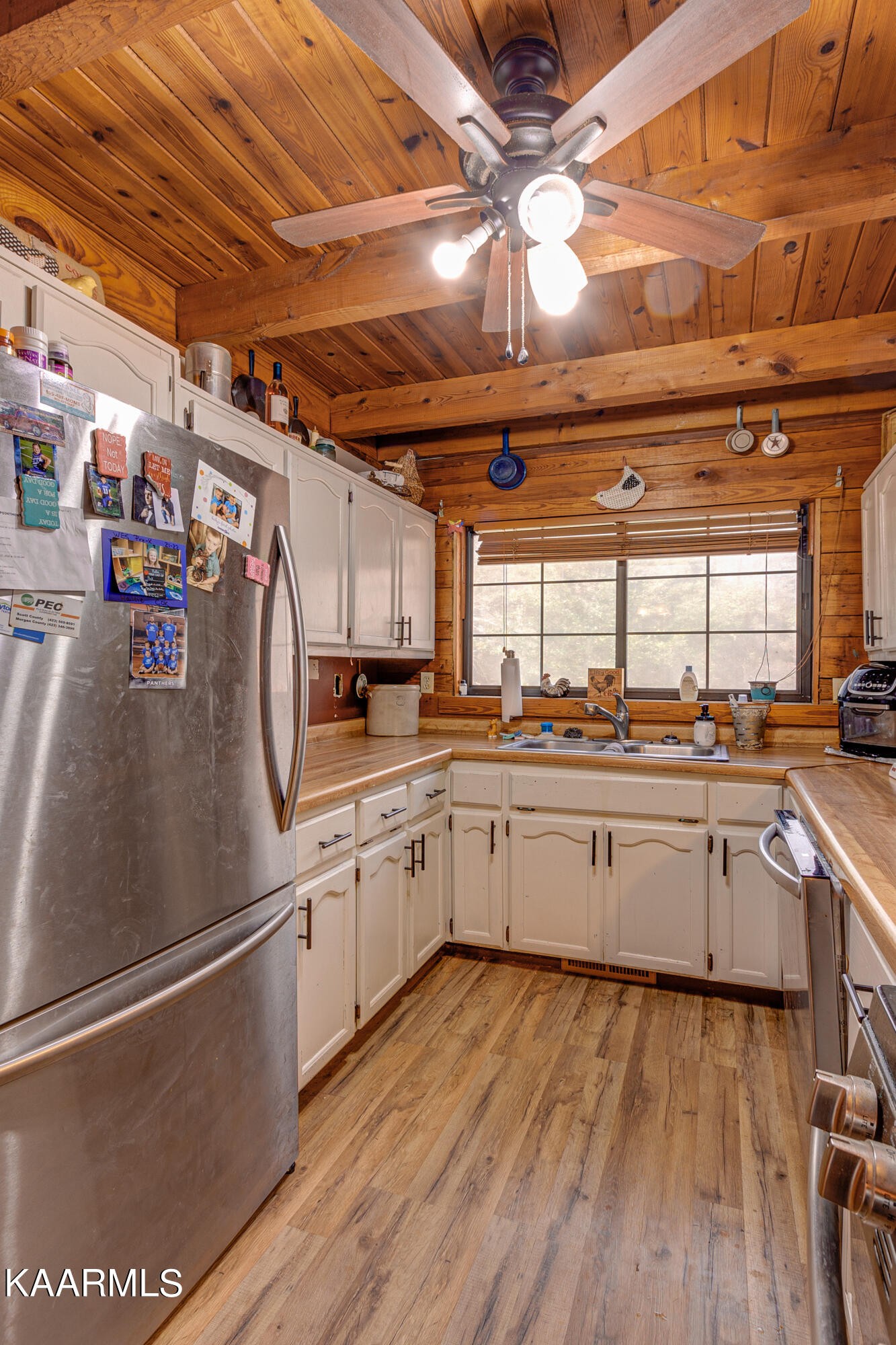 905 Williamsburg Road Winfield, TN 37892 - Photo 13 of 35 a kitchen with granite countertop a refrigerator a sink and white cabinets
