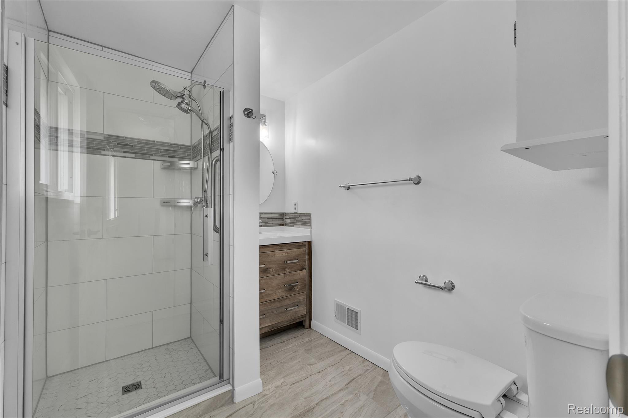 7000 Woonsocket Street Canton, MI 48187 - Photo 45 of 65 Shower with glass enclosure, white rectangular wall tiles, and horizontal accent mosaic