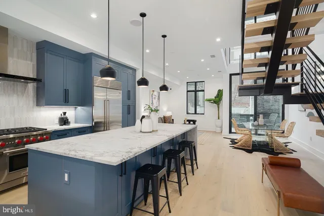 a kitchen with stainless steel appliances granite countertop a stove a sink dishwasher and a refrigerator with wooden floor