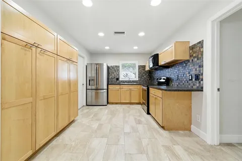 a view of a kitchen with a sink and a refrigerator