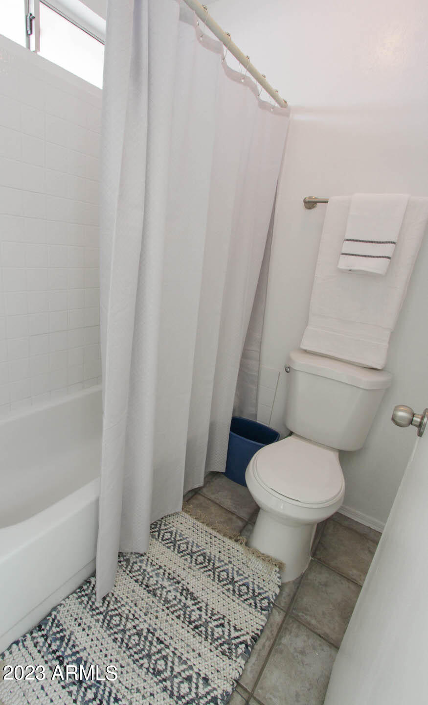 4401 West Tonto Road Glendale, AZ 85308 - Photo 24 of 29 a white toilet sitting next to a bath tub