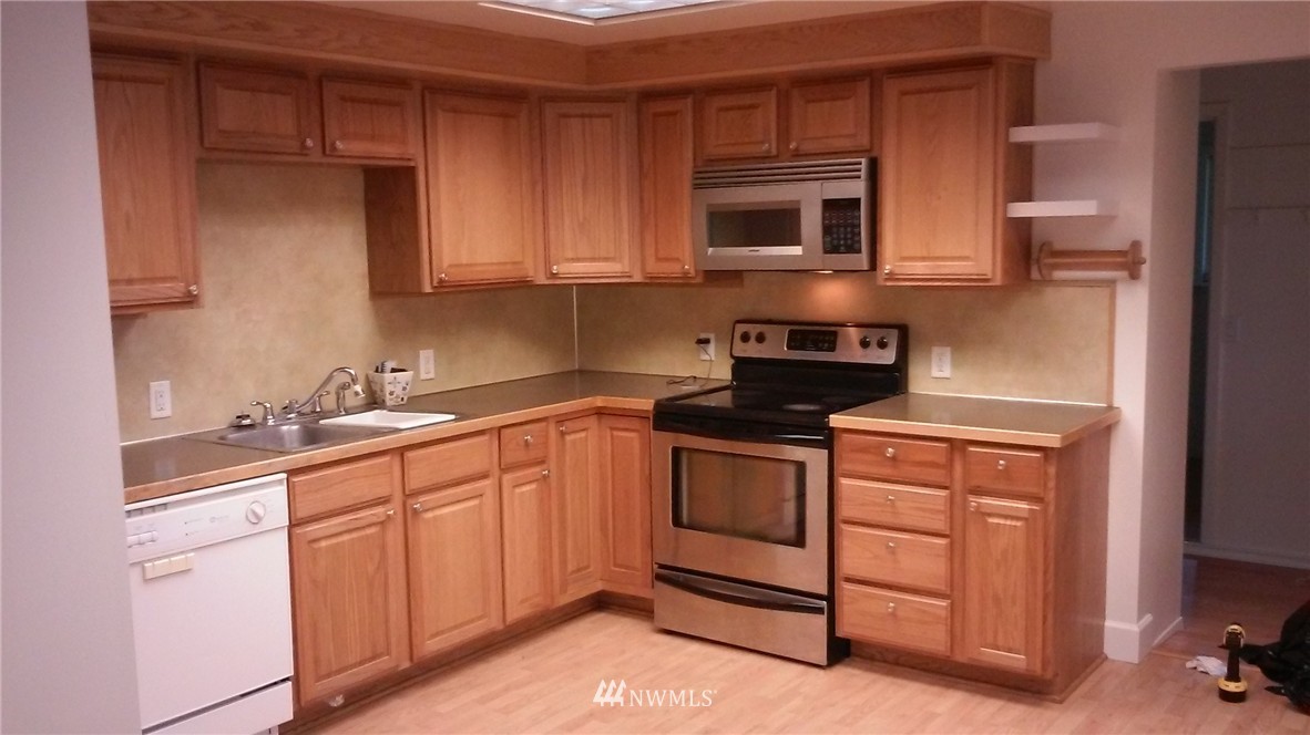 9240 Garrison Road Sumas, WA 98295 - Photo 10 of 16 a kitchen with stainless steel appliances granite countertop a stove a sink and a microwave