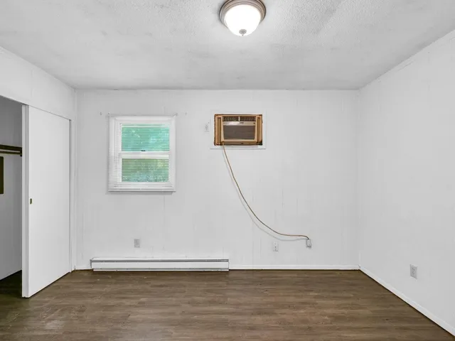 a view of a livingroom with wooden floor and a window