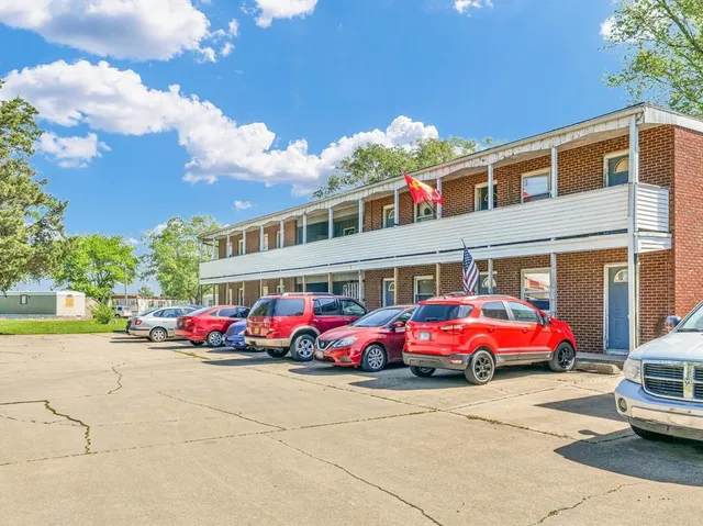 a front view of building with cars parked